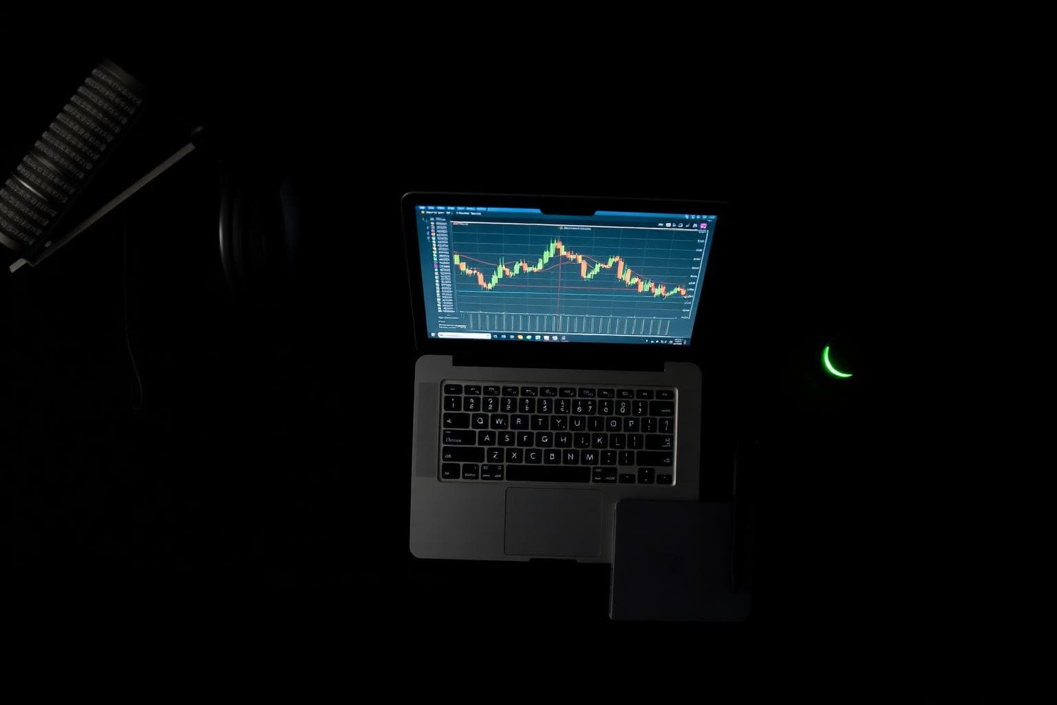 Creator's late-night workspace with laptop chart and microphone